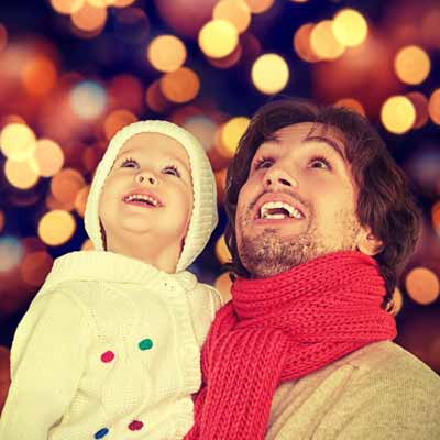 Little girl hugging her mom while they look at Christmas lights at the park