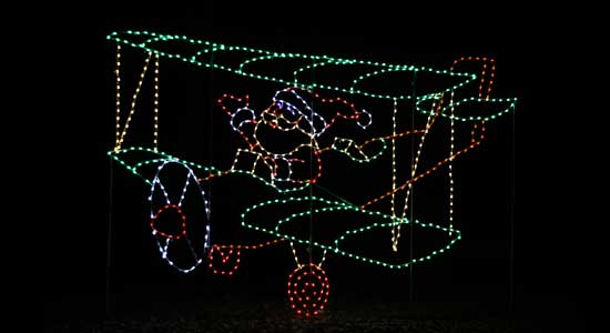 Christmas lights display of Santa flying an airplane