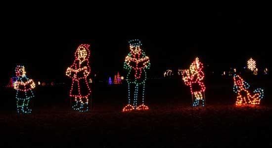 Christmas lights display of people singing Christmas carols